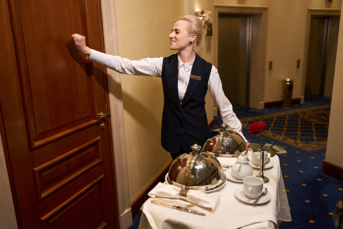 Waitress delivering room service to a door